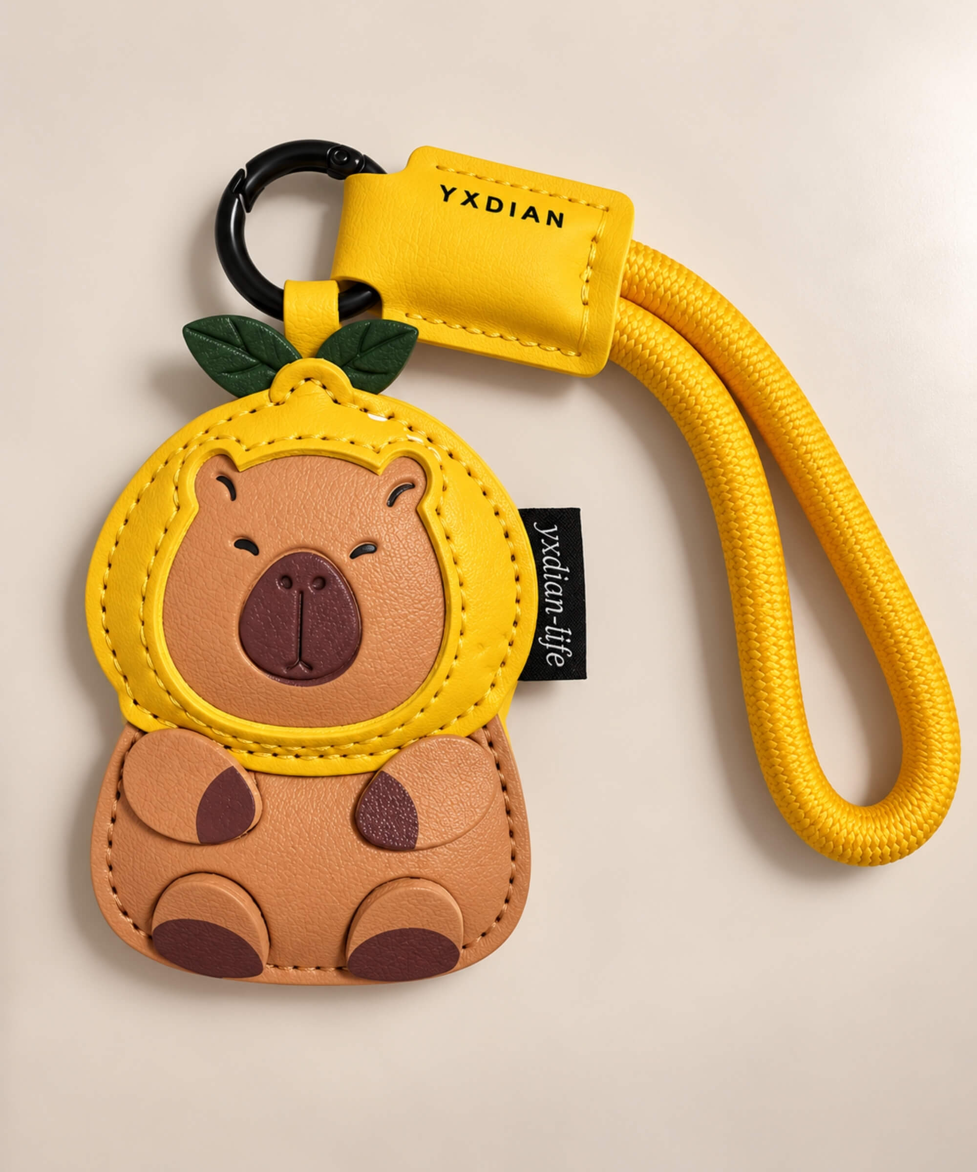 Orange Capybara PU leather bag charm keychain with yellow hood and green leaf details